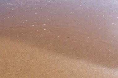 Yumuşak deniz dalga köpüğü kum plajındaki ile.