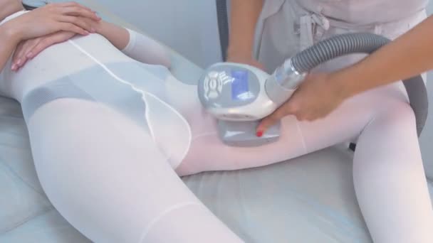 Cosmetólogo hace una mujer en traje de nylon masaje lpg en la cadera. Cadera y manos de cerca . — Vídeos de Stock