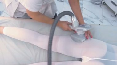 Güzellik uzmanı naylon lpg masaj kalça ve kalça üzerinde uygun bir kadın yapar. Ganimet ve eller yakın çekim.