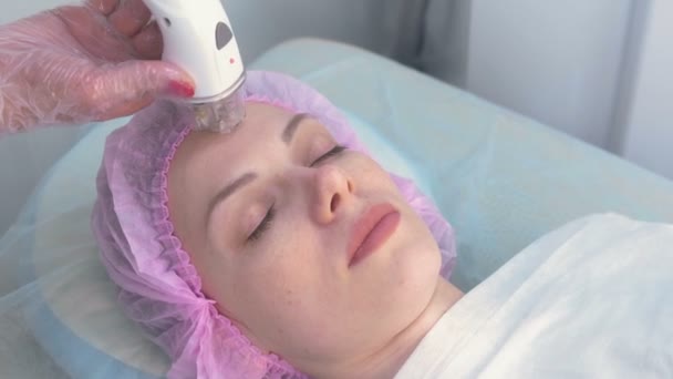 Lymfedrainage massage Lpg apparaat proces voor gezicht. Therapeut schoonheidsspecialiste maakt een verkwikkende gezichtsmassage voor de vrouw in de kliniek. Schoonheid en bodycare concept. — Stockvideo