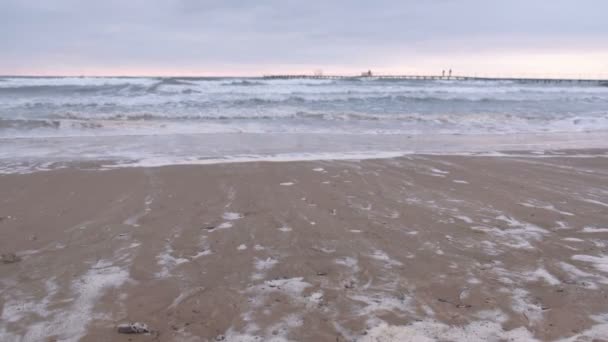 Duże burzliwy fale na morzu. Ładnym z molo, piaszczystej plaży o zachodzie słońca. — Wideo stockowe