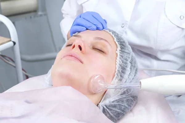 Beauty behandeling gezicht elektrische darsonval therapie bij cosmetologie kliniek. — Stockfoto