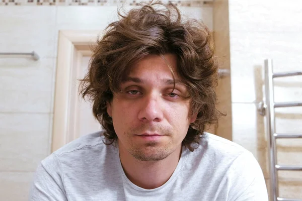 Sabahları banyo aynada uykulu shaggy delikanlı bakar.