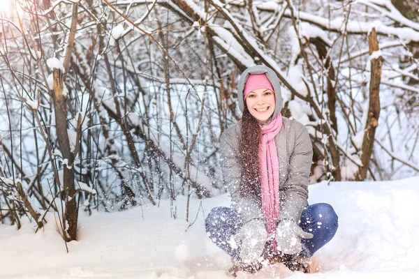 Jovem bonita na floresta de inverno jogando em bolas de neve . — Fotografia de Stock