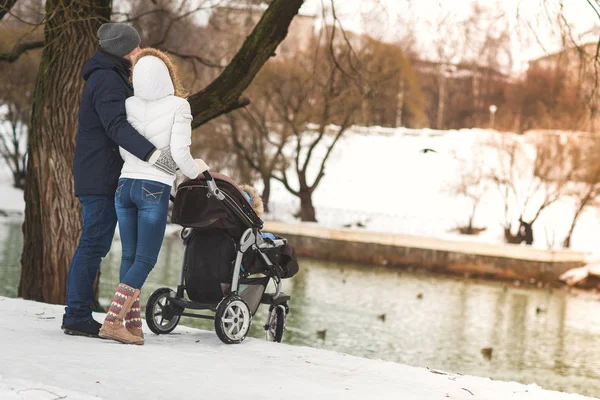 Счастливая молодая семья, гуляющая в зимнем парке, мама, папа и сын в прогулках . — стоковое фото