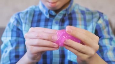 Çocuklar el yoğurmak, sıkmak ve pembe bir sümük germek. Çocuk çamur ile çalış.