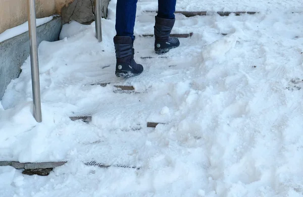 滑りやすい階段。ダウン ジャケットの雪に覆われた階段を青でクローズ アップ梨花足. — ストック写真