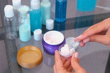Kadın el kremi bir spatula ile küçük bir büyük kavanozdan koyun. Kozmetik yol kümesi.