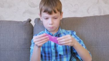 Mutlu çocuk koç üzerinde oturan ve oynarken pembe bir sümük germe