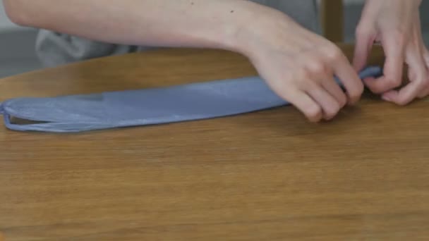 Donna piega con attenzione i sacchetti di plastica per il riutilizzo. Mani in primo piano . — Video Stock