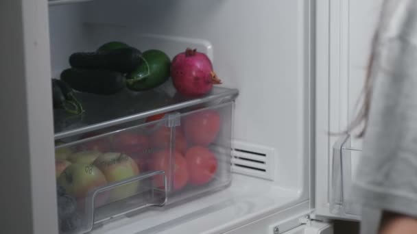 Woman takes out of the fridge mandarins at night. Close-up hands. — Stock Video