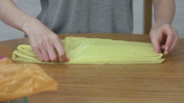 Vrouw plooien zorgvuldig de plastic zakken voor hergebruik. Close-up handen. — Stockvideo