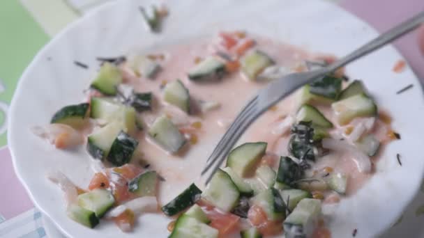 Man eet groente salade met een vork. — Stockvideo