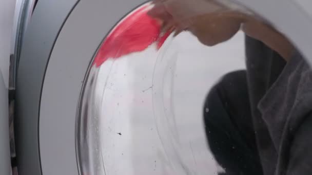 Женщина в красных резиновых перчатках стирает стиральную машину с губкой . — стоковое видео