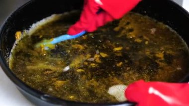 Su ve yağ ile tepsi pişirme yıkama maddesi ile ıslatılmış Kırmızı lastik eldiven yıkama WOMANS eller.