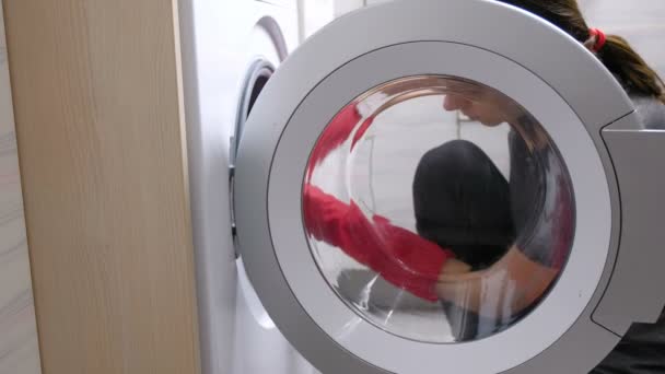 Kvinna i röd gummihandskar tvätt tvättmaskin med svamp. — Stockvideo