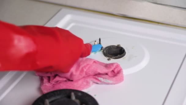 Mãos femininas em luvas de borracha vermelha lava fogão a gás sujo com uma escova e esponja . — Vídeo de Stock
