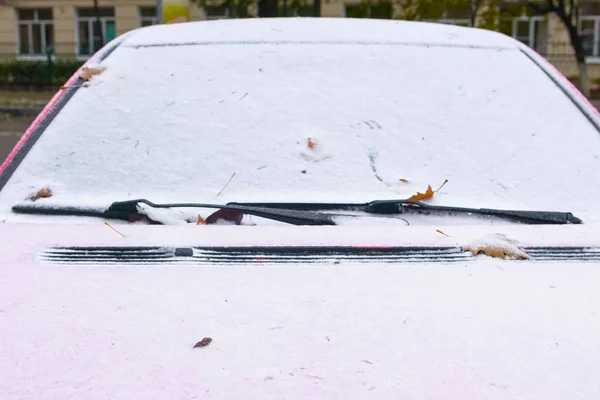 冬の日、ビューのフロント ウィンドウのフロント ガラスとボンネットで覆われた赤い車の雪を凍結. — ストック写真