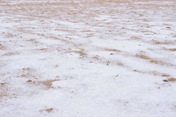 Praia de areia com neve na areia vista close-up . — Fotografia de Stock