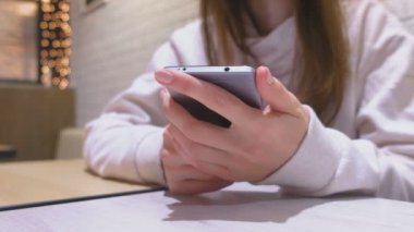 Kadın üstünde hareket eden telefon, eller yakın çekim bir ileti yazmakta olduğunu.