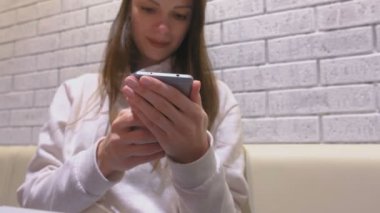 Kadın oturuyor ve biri kafede bekliyorum cep telefonunda bir mesaj yazarak.