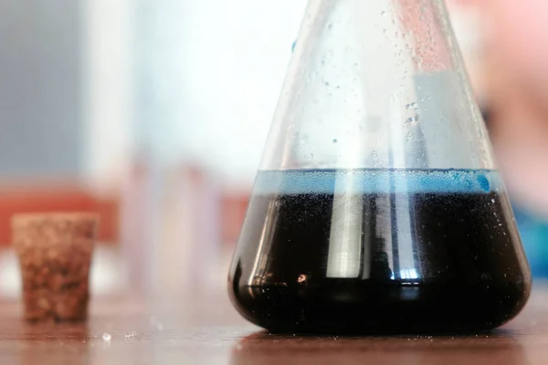 Experimentos de química. Reacción química con la liberación de gas en el matraz sobre la mesa . — Foto de Stock