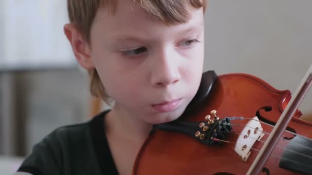 Menino de 8 anos está aprendendo a tocar violino . — Vídeo de Stock