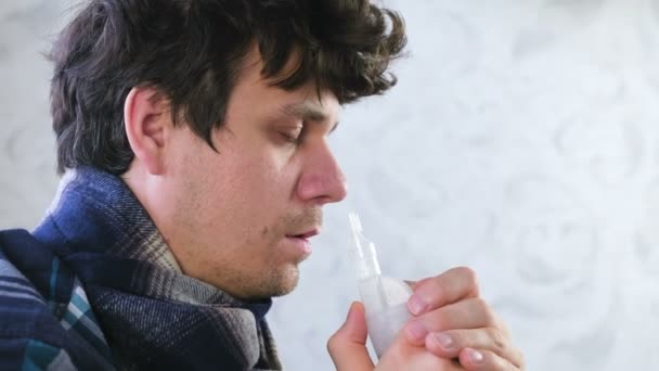 Hombre enfermo inhalando a través de la boquilla del inhalador para la nariz. Cara de cerca, vista lateral. Utilice nebulizador e inhalador para el tratamiento . — Vídeo de stock