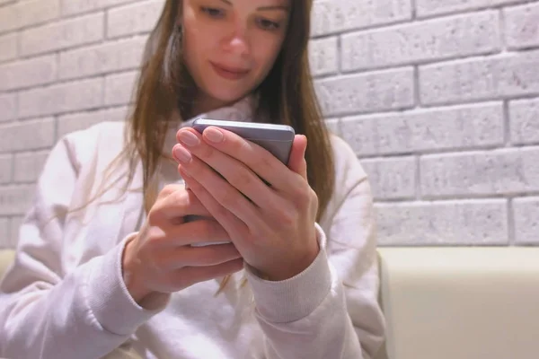 Mujer está escribiendo un mensaje en el teléfono móvil sentado y esperando a alguien en la cafetería . — Foto de Stock