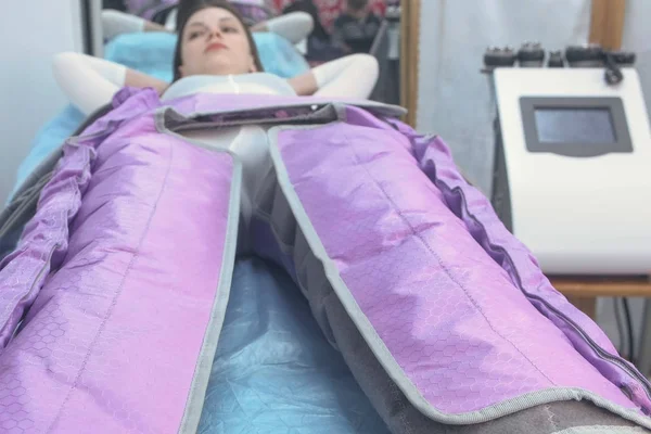 Mujer en la clínica en el tratamiento de la terapia de presión procedimiento para las piernas . — Foto de Stock