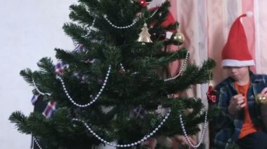 Anne ve oğlu Noel şapka içinde boncuk ve topları ile Noel ağacı süslemeleri.