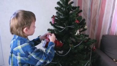 Anne ve oğlu Noel şapka içinde Noel ağacı evde yükleyin. Noel için hazırlamak.