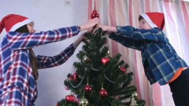 Anne ve oğlu Noel şapka içinde Noel ağacının üstüne spire ayarla.