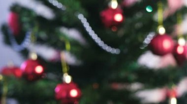 Kırmızı parlak topları ve altın oyuncaklar Noel ağacı dalları üzerinde. Noel ağacı ışıkları ile Noel çelenk. Bulanıklık.