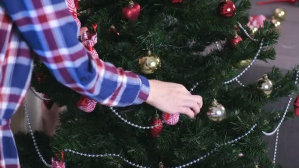 Kvinna i jul hatt dekorera julgran med kulor hemma. Händer närbild. — Stockvideo