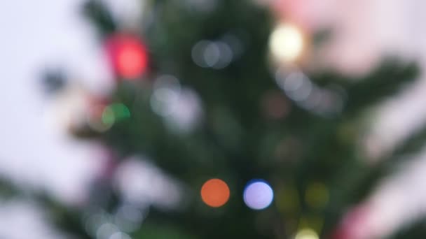 Pelotas rojas brillantes y juguetes dorados en las ramas del árbol de Navidad. Guirnalda de Navidad con luces en el árbol de Navidad. Desenfoque . — Vídeos de Stock