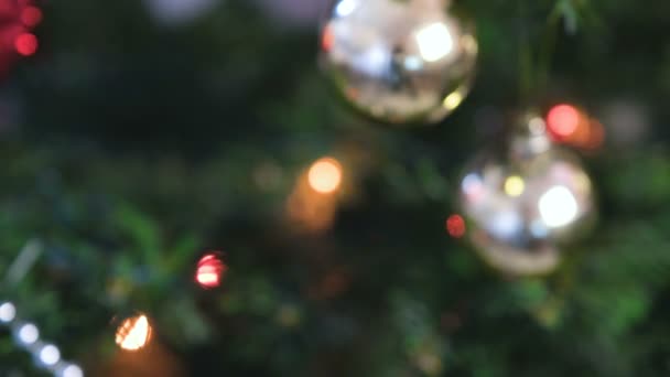 Bola yang berbeda dan mainan emas di cabang pohon Natal. Karangan bunga Natal dengan lampu di pohon Natal. Kabur . — Stok Video