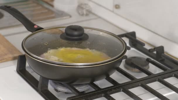 Приготовление яичницы с колбасой в сковороде на газовой плите . — стоковое видео
