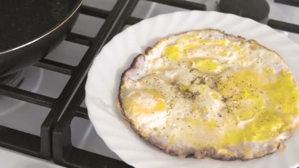 Míchaná vejce na bílé plotně na plynový sporák v kuchyni. — Stock video