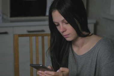 Tek genç kadın bir mesaj geceleri mutfakta türleri.