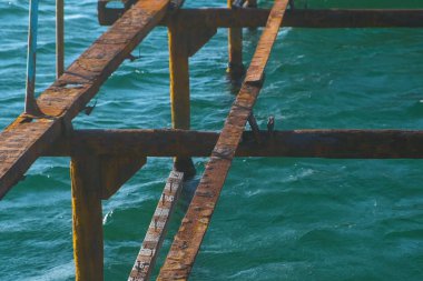 Denizin üzerinde eski ahşap iskele yok. Paslı çelik çerçeve, onarım.