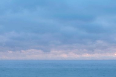 Pembe günbatımı ve mavi bulutlar güzel deniz manzarası. Sakin deniz.