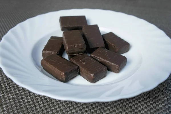 Chocolate candies on a white plate. Concept of unhealthy eating. — Stock Photo, Image