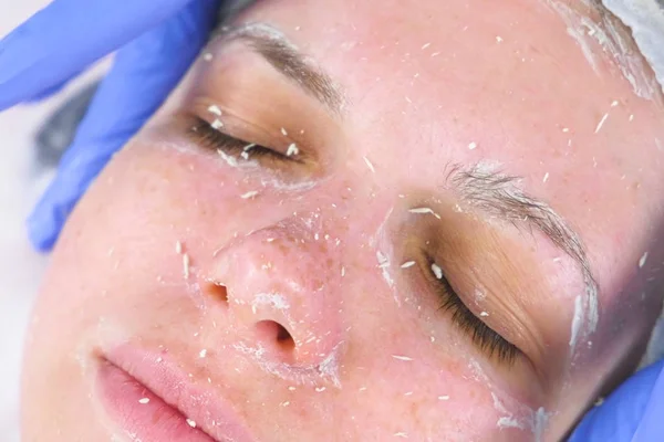 Kosmetolog ruller masken på kvinderne står massage bevægelser. Kosmetolog ansigtsbehandling. Ansigt close-up . - Stock-foto