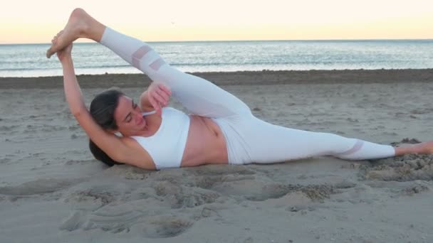 Young Woman Doing Yoga Nantasana Side Reclining Leg Lift Sandy — Stock Video