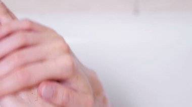 Eller, soyma kadın köpük banyoda yalan ellerini bir bodur koyar. Eller yakın çekim. Beyaz arka plan.