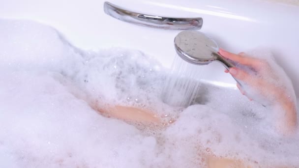 La mujer se está bañando con espuma. Ella vierte su agua corporal de la ducha. Primer plano de espuma . — Vídeo de stock