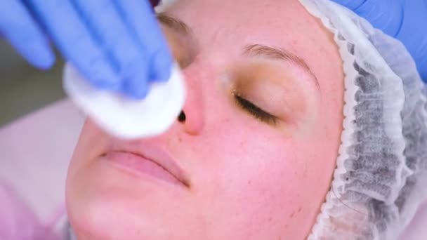 Cosmetologist washes womans face using cotton pads. Preparing for a cleaning face. — Stock Video