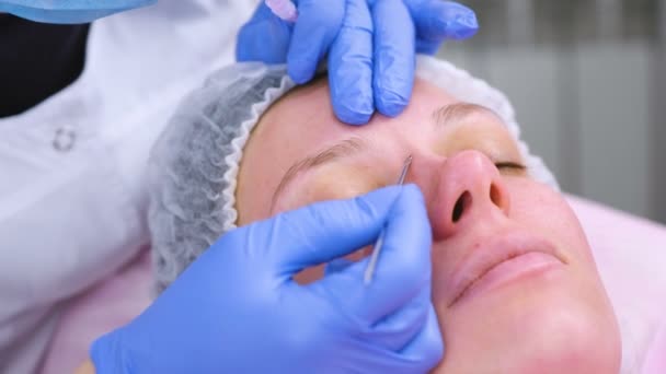 Limpieza mecánica de la cara en el esteticista. Cosmetólogo apretar el acné en la cara de la aguja médica del paciente . — Vídeos de Stock