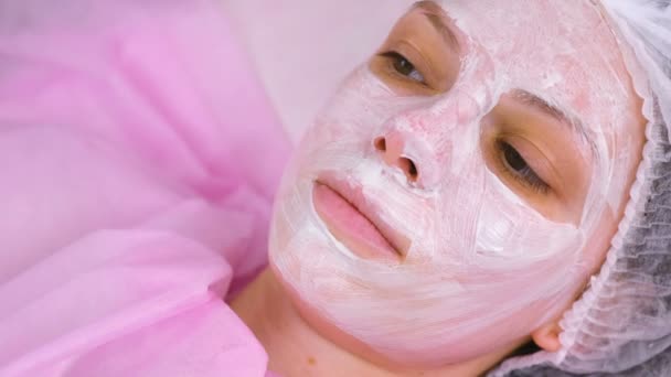 Vrouw gezicht met hydraterende masker op de cosmetologie-procedure. Gezicht close-up. — Stockvideo